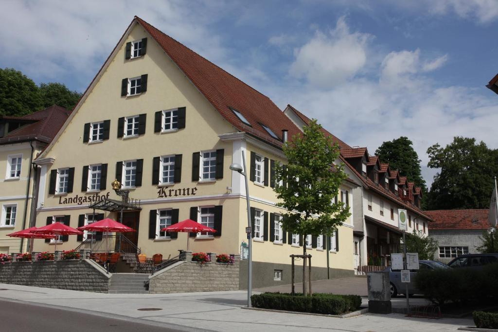 a building with red umbrellas in front of it at Hotel Krone in Niederstotzingen