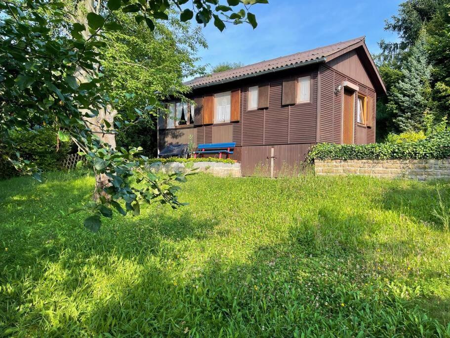 ein Haus in einem Garten mit grünem Rasen in der Unterkunft Kleines & feines Holzhaus in der Natur in Eschwege