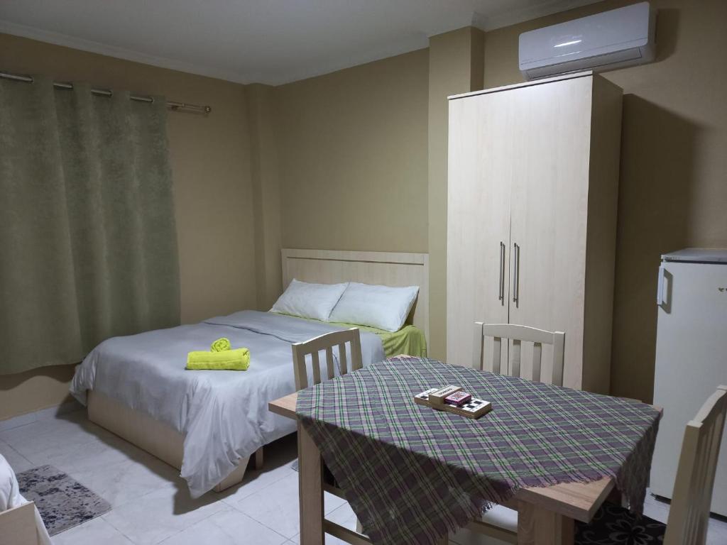 um quarto com uma cama e uma mesa com uma toalha amarela em Klev's apartments em Shkodër