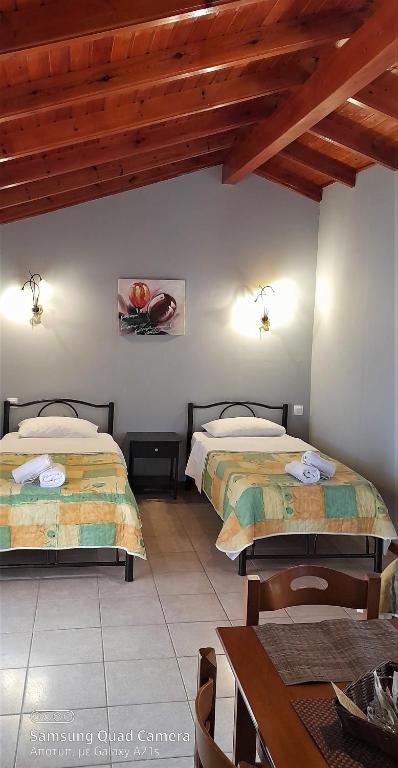 una camera con due letti e un tavolo con un tavolo di Stefanosplace ApartHotel Sea View a Barbati