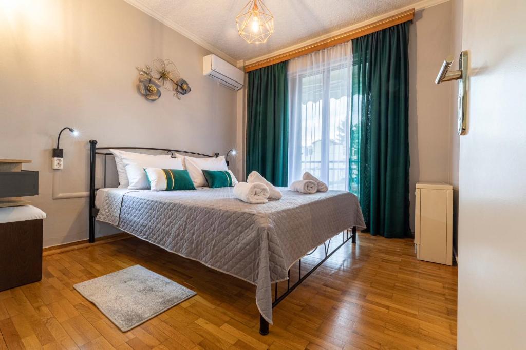 a bedroom with a bed with green curtains and a window at Johnny's Three Bedroom Apartment in Nafplio