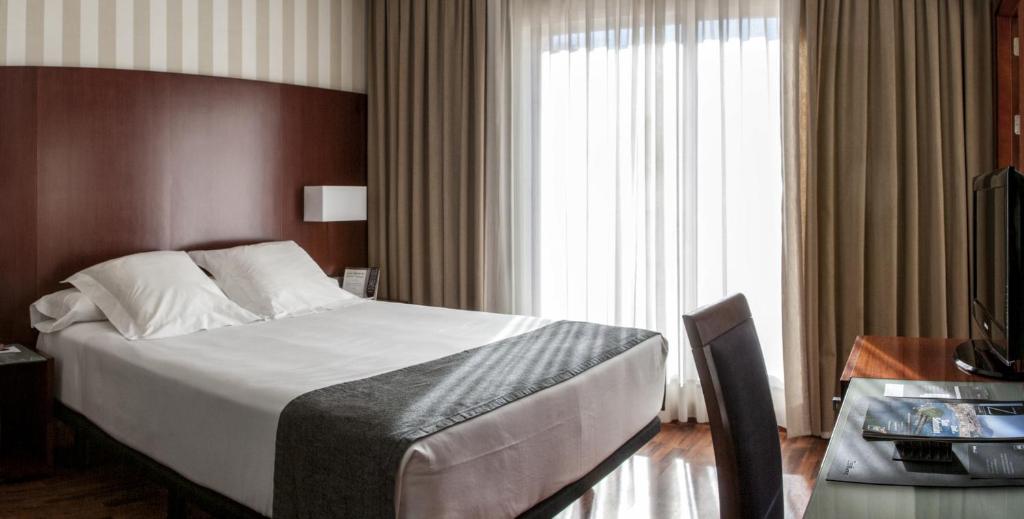 a hotel room with a bed and a window at Zenit Málaga in Málaga