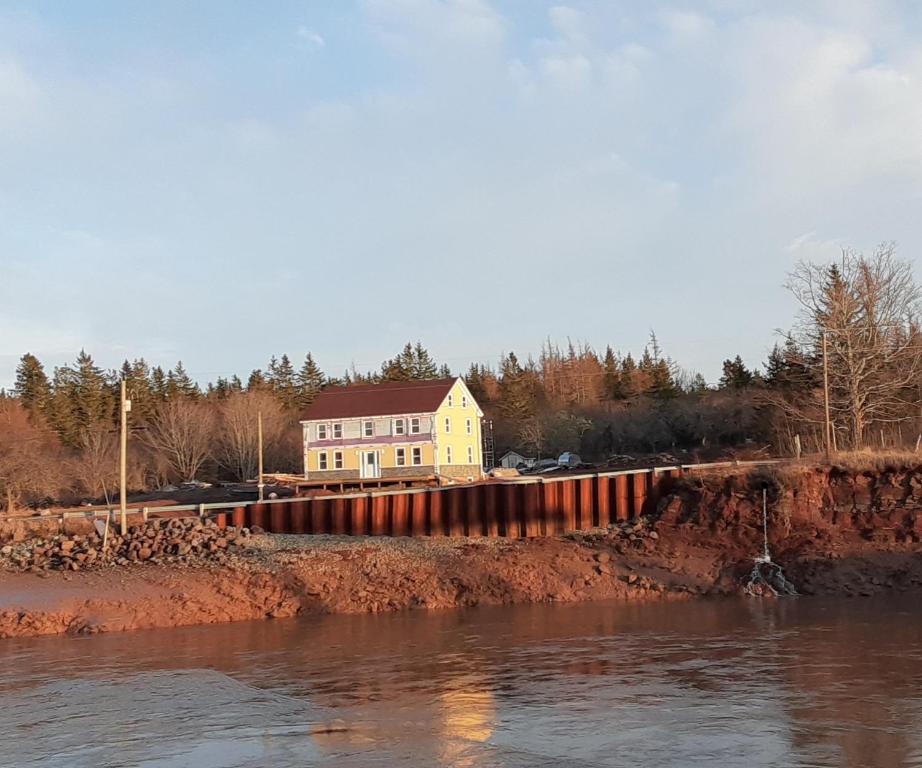 ein Haus hinter einem Zaun neben einem Fluss in der Unterkunft Mountainview Solitude Inn in Riverside