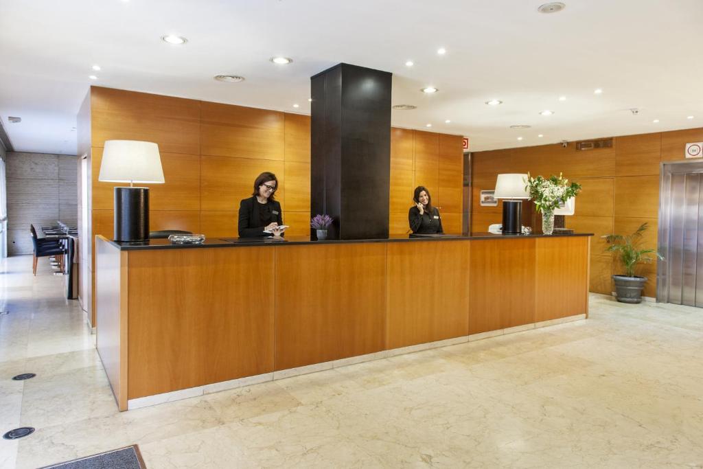 two women sitting at a reception desk in a lobby at Zenit Málaga in Málaga