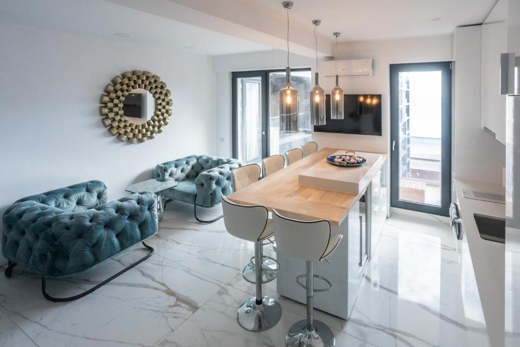a living room with a dining room table and chairs at Luxury by the Sea in Năvodari