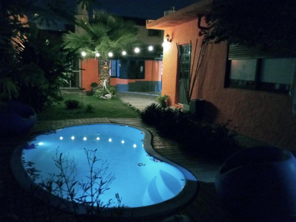 una piscina en el patio de una casa por la noche en Casargentina Apart Depto entero Baño privado 15min Ezeiza en Monte Grande