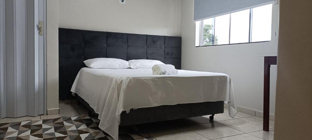 a bedroom with a large bed with a black headboard at Hotel Pires Faxinal in Faxinal