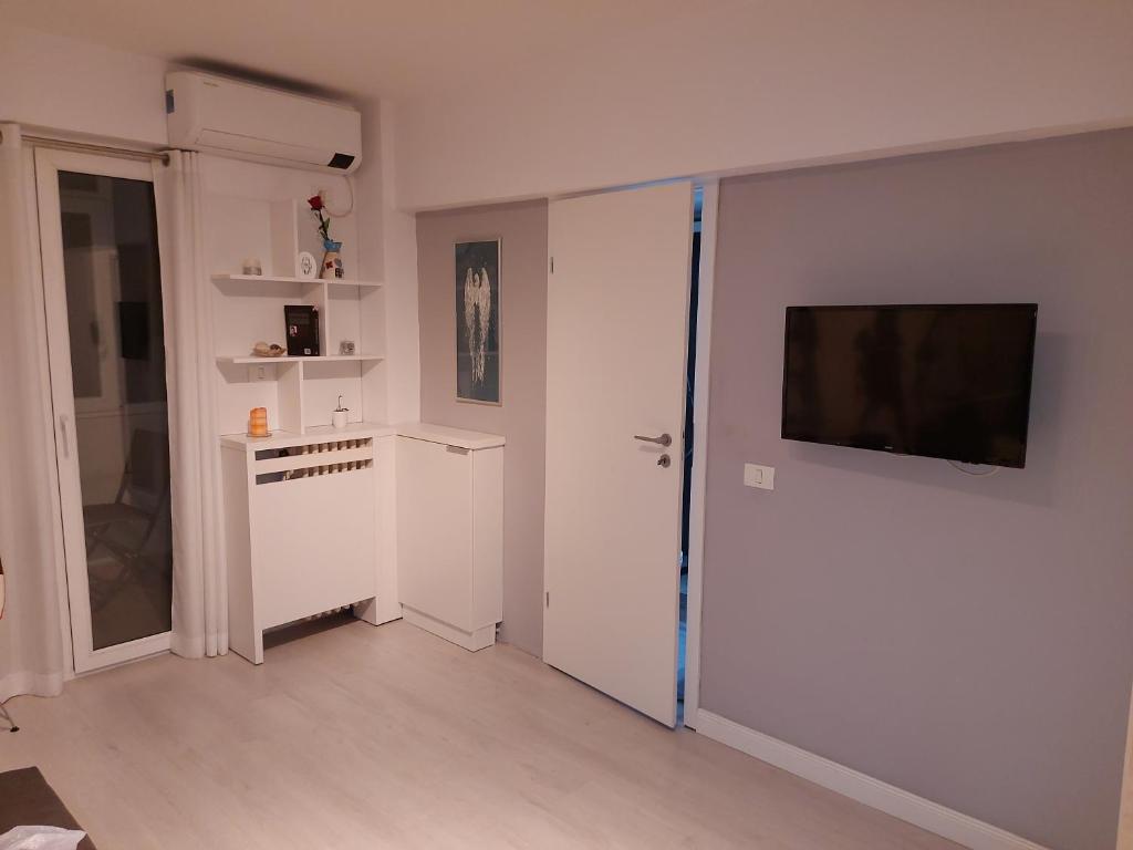 ein Wohnzimmer mit einem TV und einer weißen Wand in der Unterkunft OldTown Studio in Bukarest