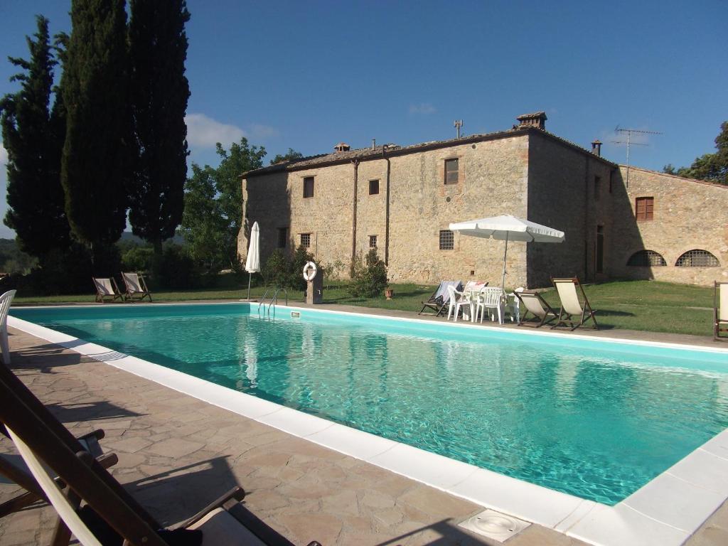 a swimming pool in front of a building at Agriturismo Natura E Salute in San Gimignano