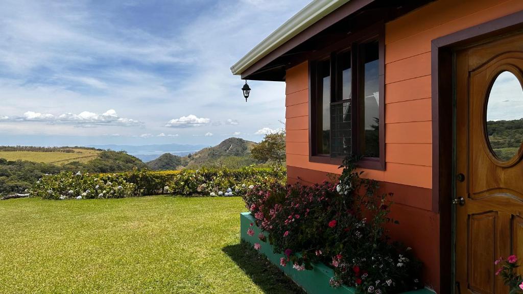 ein Haus mit einem Fenster, einer Tür und Blumen in der Unterkunft Campo Azul - Monteverde in Monteverde Costa Rica
