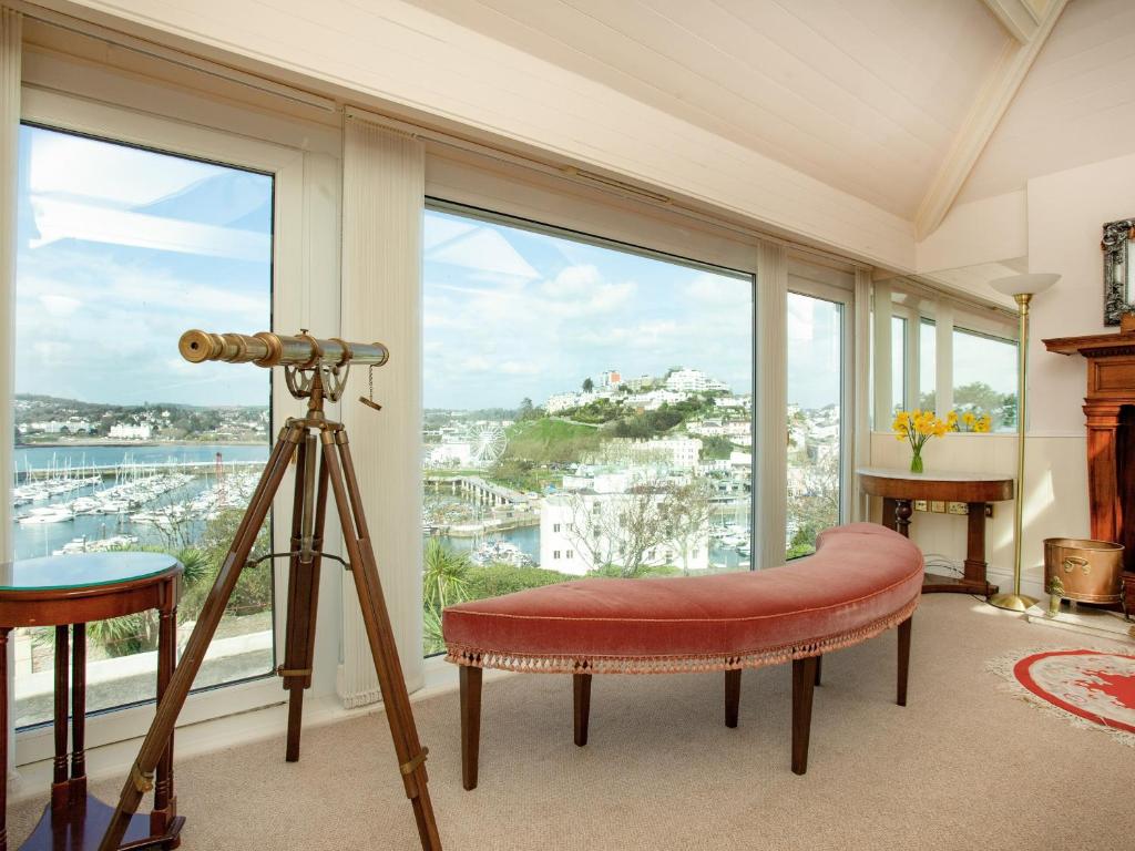托基的住宿－Riviera View，窗户前的带摄像头和长凳的房间