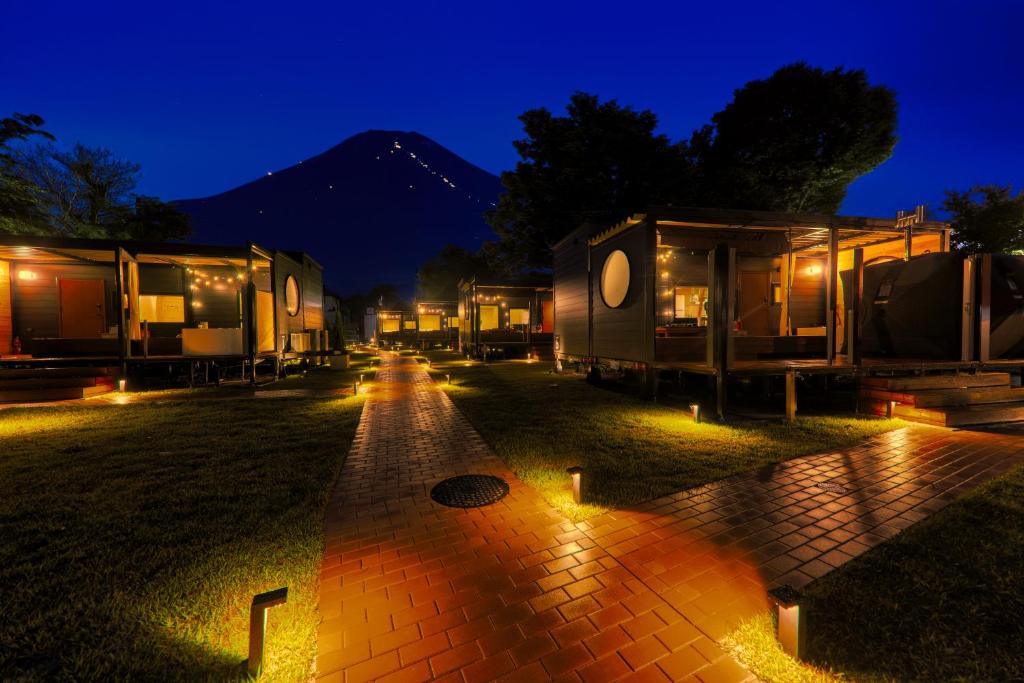 山中湖村にあるPiilo asobi&stayの夜間の野原に停まった一連のRVS