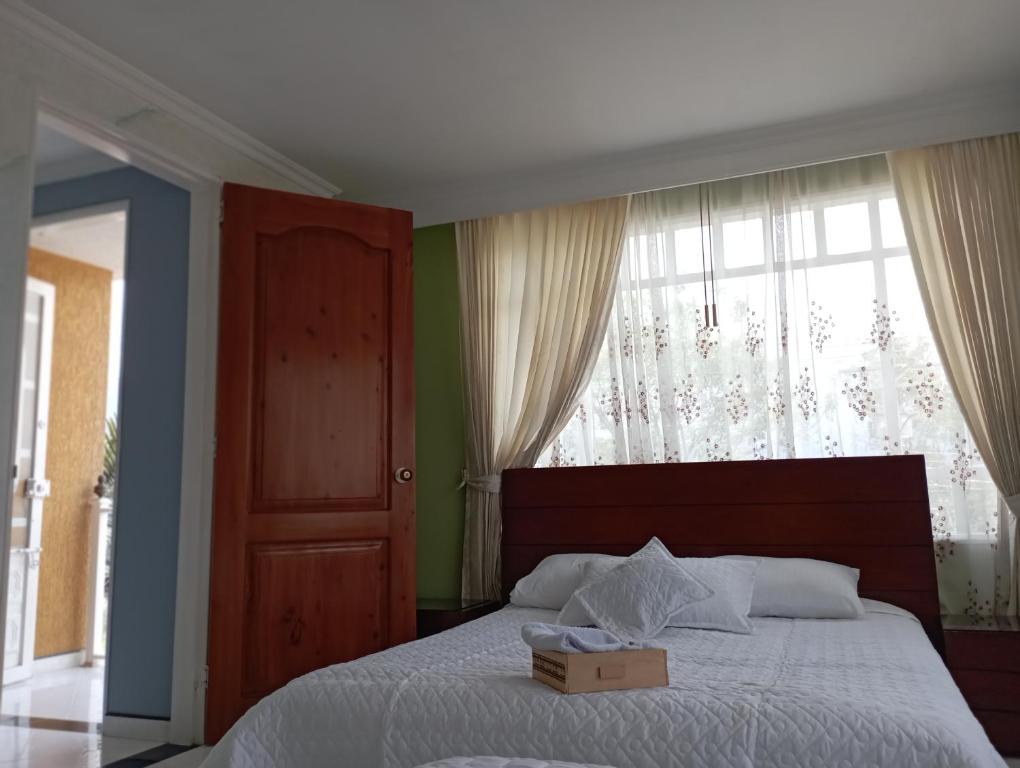 Schlafzimmer mit einem großen Bett und einem Fenster in der Unterkunft CASA DE LA ABUELITA in Choachí