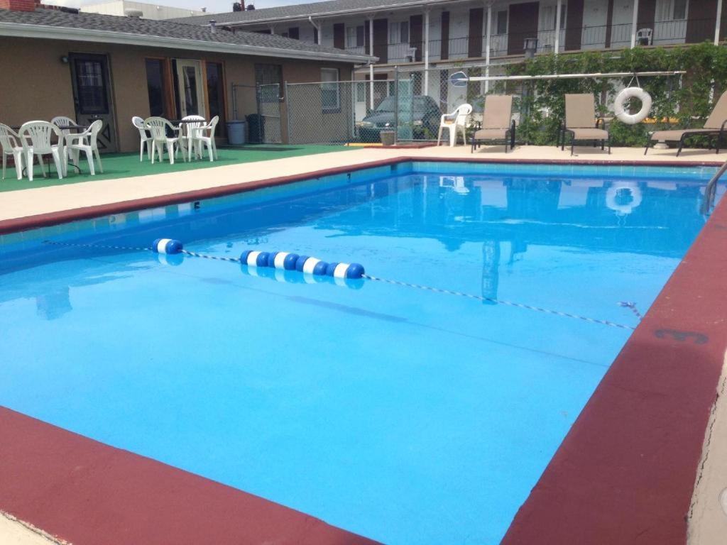 拉皮德城的住宿－Town House Motel with Pool near Mt. Rushmore，一座配有桌椅的酒店游泳池