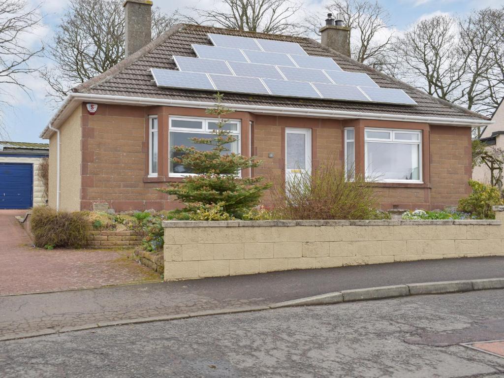 uma casa com um monte de painéis solares no telhado em The Shieling em Biggar