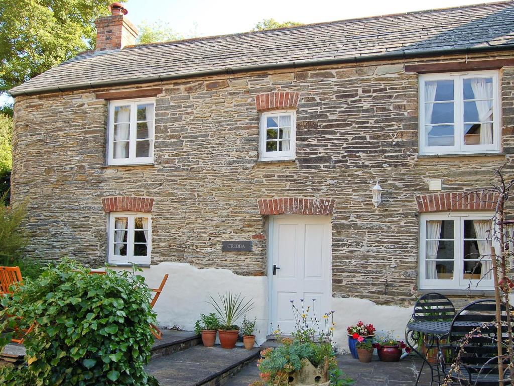 a brick house with a white door and windows at Cribba in Wadebridge