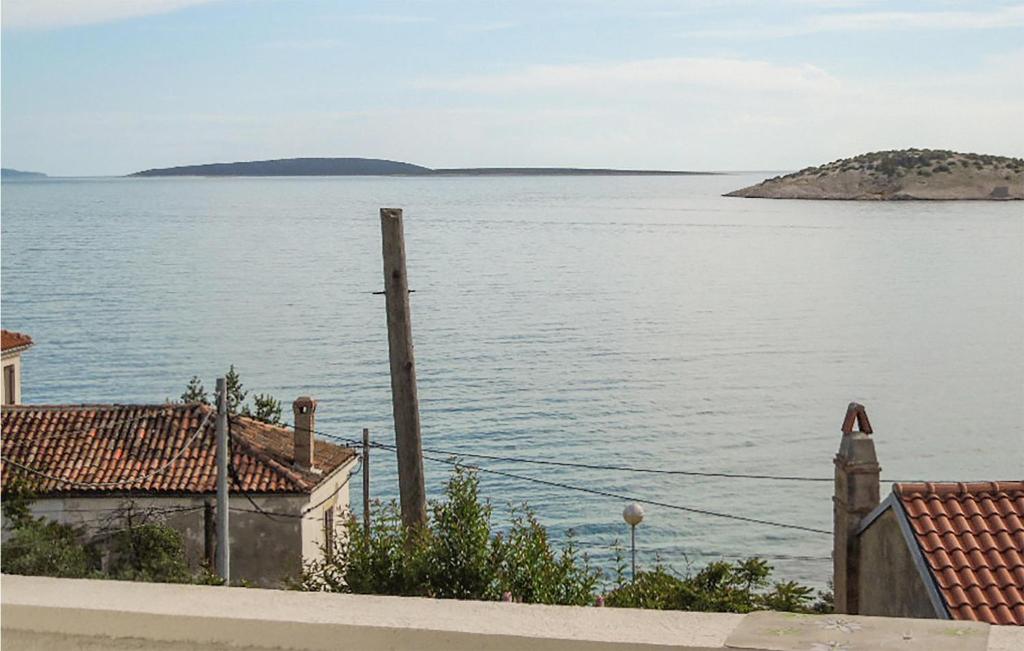 a view of a large body of water with houses at Pet Friendly Apartment In Martinscica With Kitchen in Martinšćica