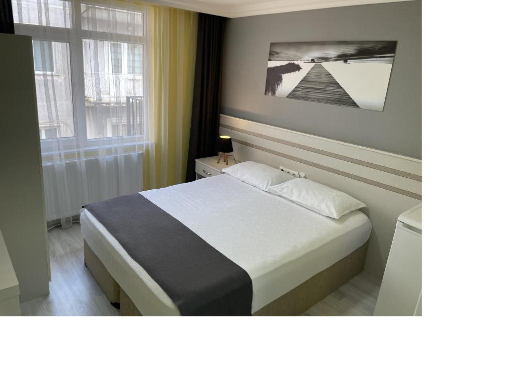 a bedroom with a bed and two windows at Kaleroom EDİRNE in Edirne