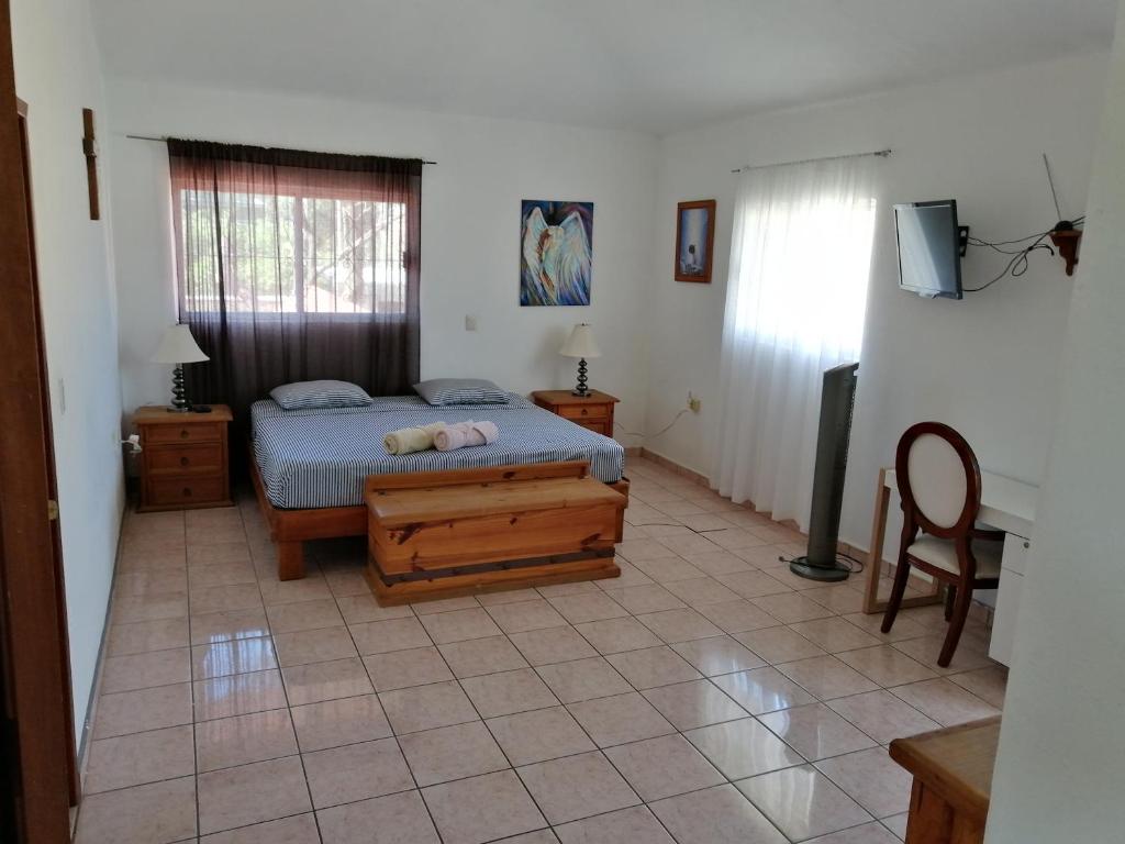 1 dormitorio con 1 cama y TV en Casa Las Animas, en El Carmen