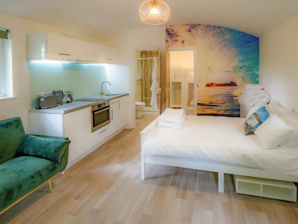 a bedroom with a large white bed and a kitchen at Owl - Uk43447 in Hayle