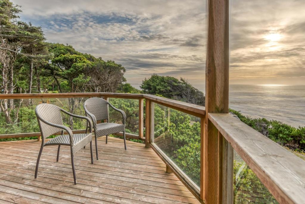 two chairs on the deck of a house overlooking the ocean at The Lookout in Newport