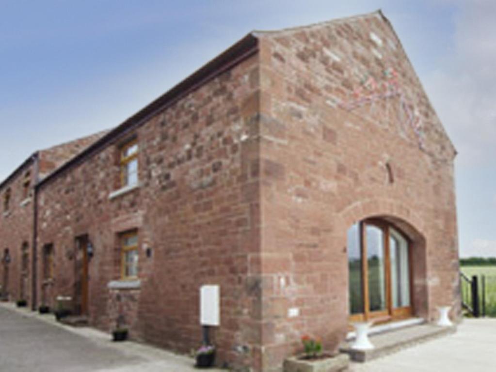 a brick building with an archway on the side of it at Sunset View-e4107a in Aspatria