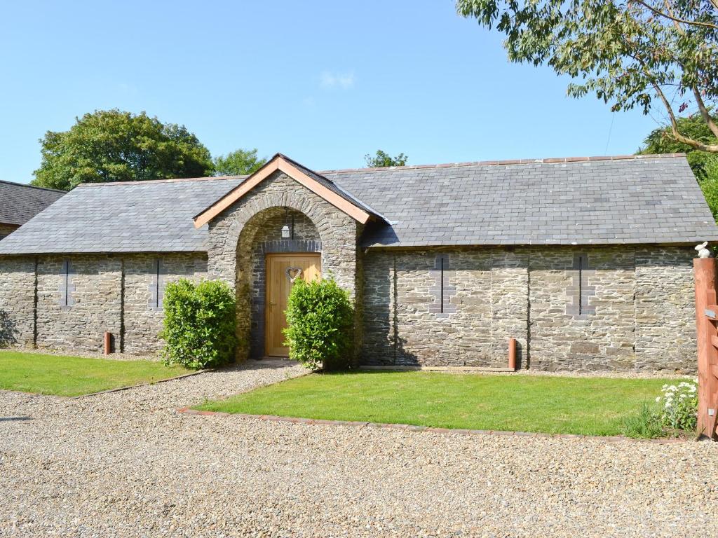 an old stone house with a driveway at Pendre Isaf in Pentre-briwnant