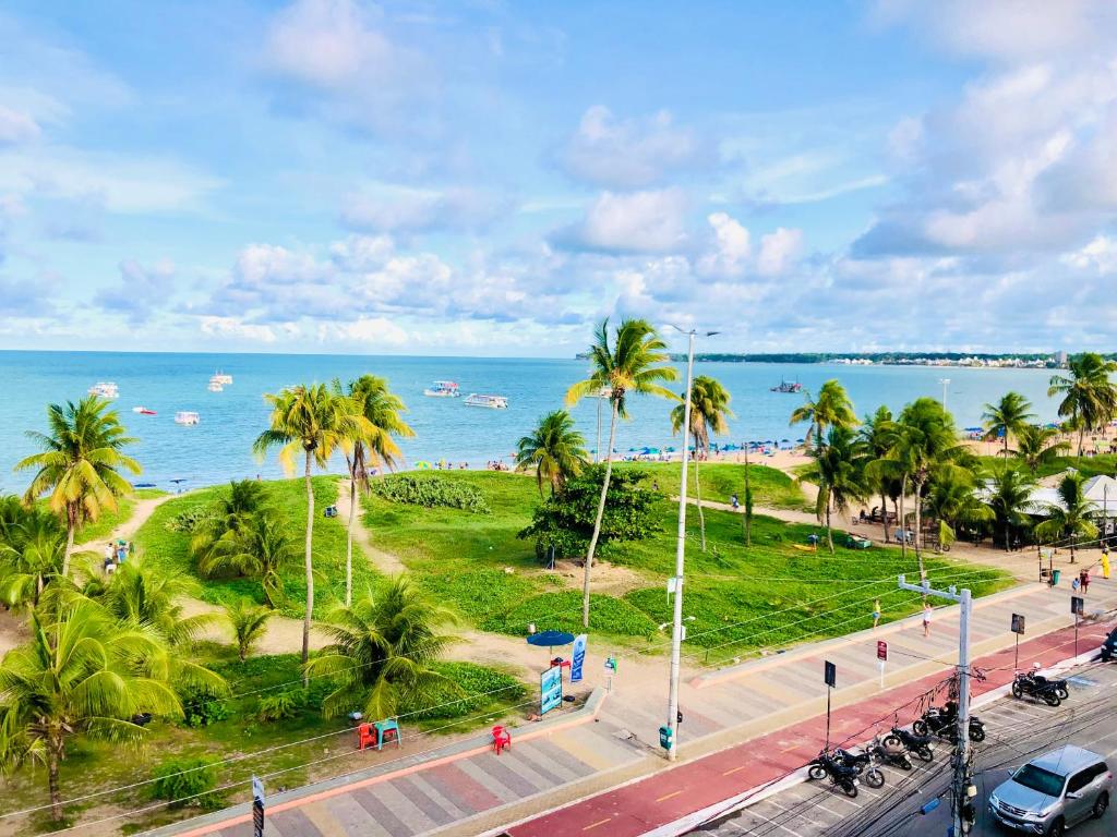 a view of the beach with palm trees and the ocean at Tambaú Home Beira Mar - com varanda in João Pessoa