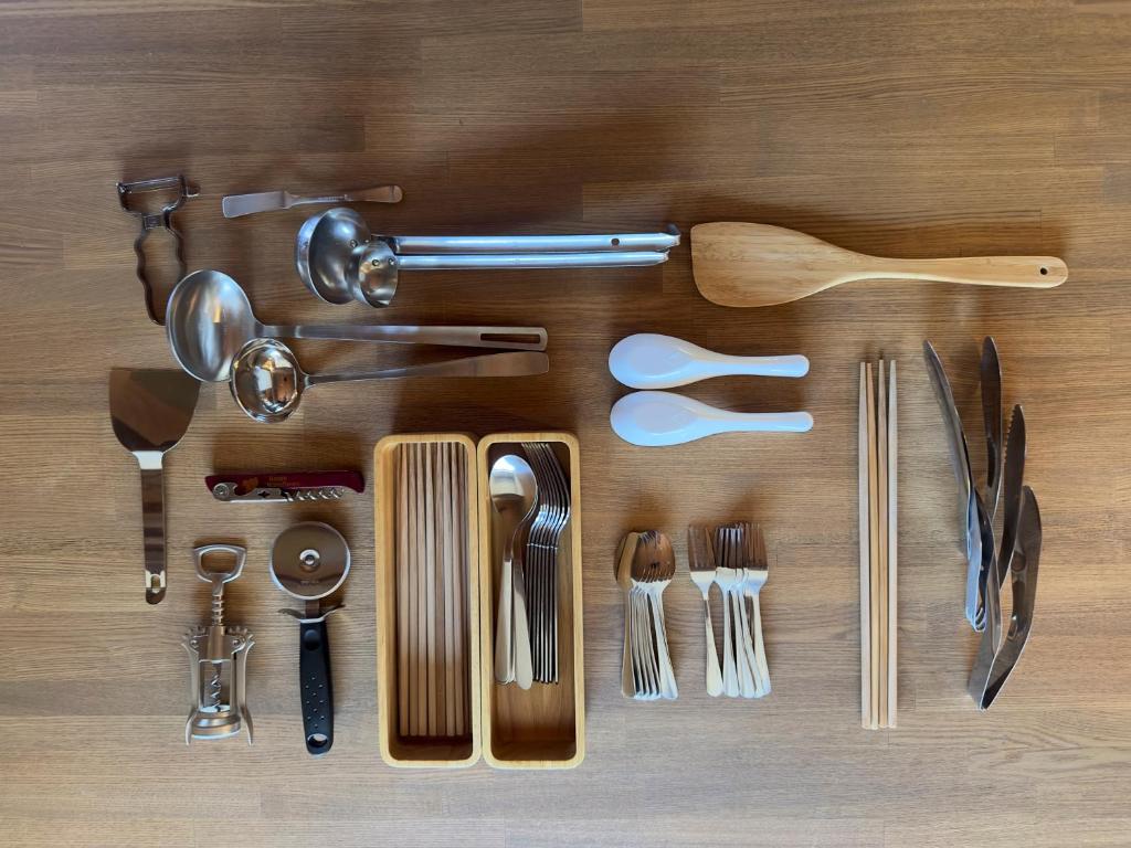 a bunch of kitchen utensils on a wooden table at TEMPLESTAY ZENSŌ in Chiyodamachi