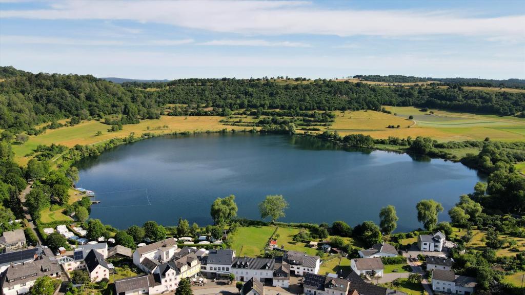 einem Luftblick auf einen See in einem Dorf in der Unterkunft Ferienwohnung Seeblick in Schalkenmehren