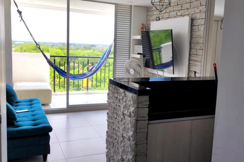 a living room with a blue couch and a balcony at Apto en Girardot con Balcón, Piscina y Parqueadero in Girardot