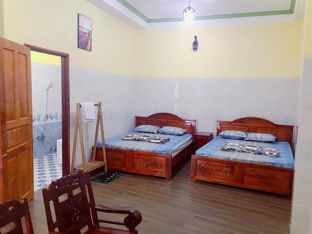 a bedroom with two twin beds and a mirror at Khách sạn Thanh Bình Bến Lức in Bến Lức