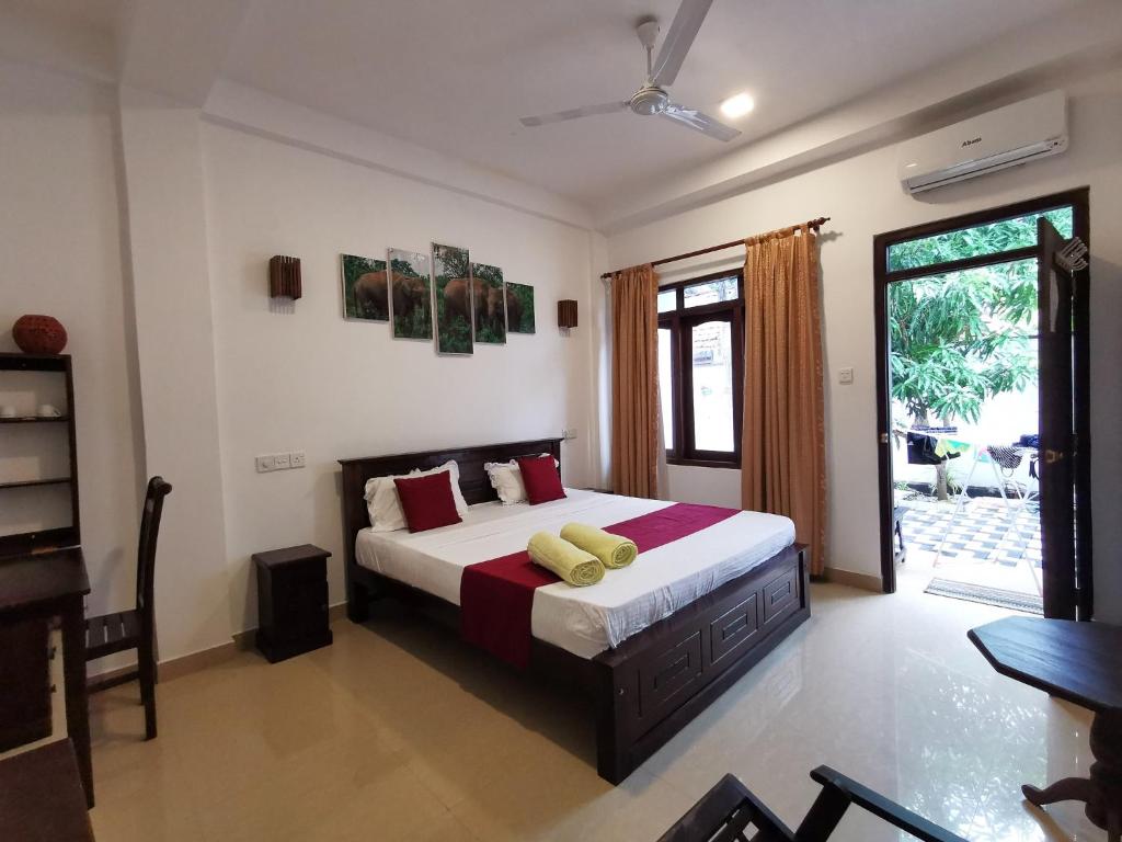 a bedroom with a large bed with red pillows at Weligama Watergate in Weligama