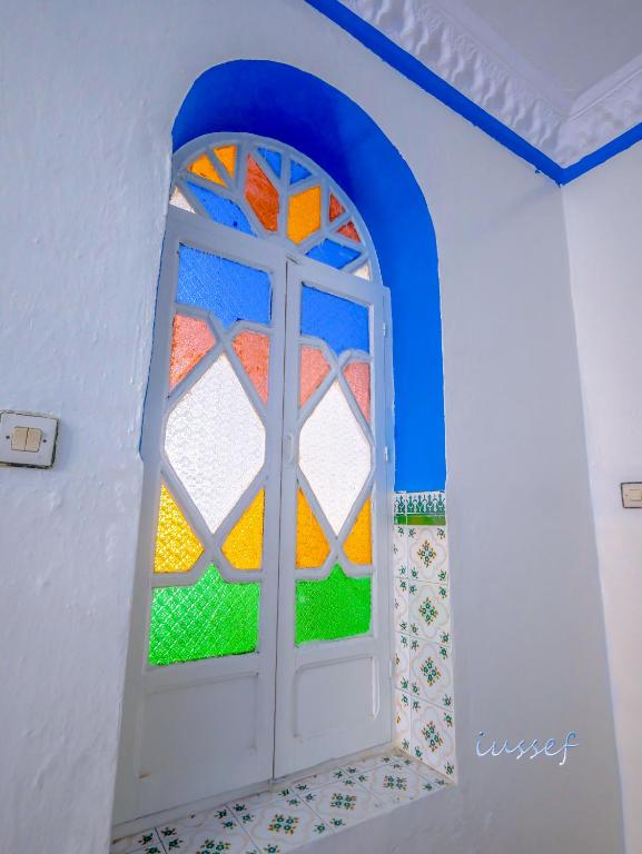 une porte avec fenêtre dans une pièce dans l'établissement AL JANAH, à Chefchaouen