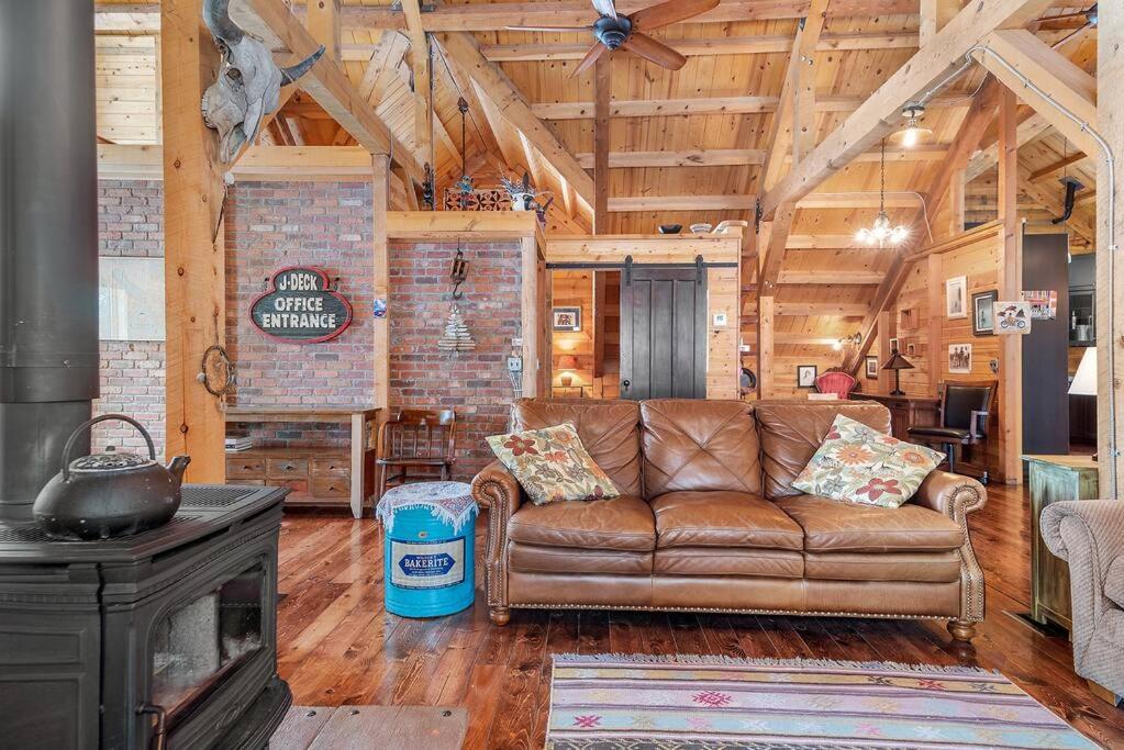a leather couch in a living room with a fireplace at Secluded Black Hills Cabin in Nemo