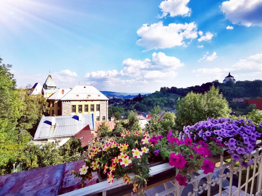 een balkon met bloemen en uitzicht op de stad bij Apartmány Michal in Banská Štiavnica