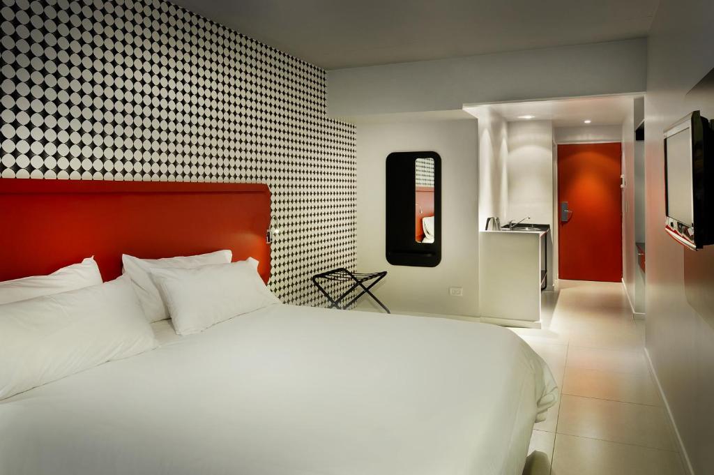 Un dormitorio con una gran cama blanca y una pared en Velasco House en Buenos Aires