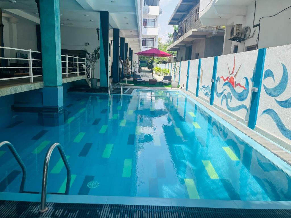 a swimming pool with blue water in a building at The Bay in Arugam Bay