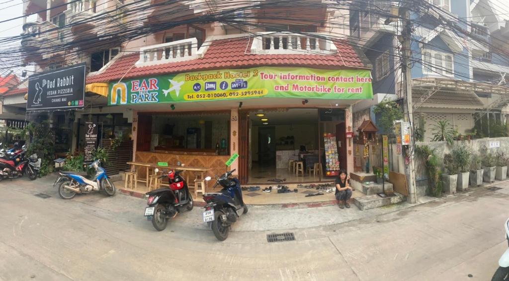 a building with motorcycles parked in front of it at Nearthepark Backpack Hostel 3 in Chiang Mai