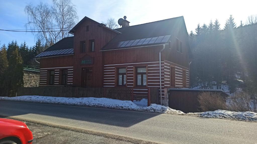 ein großes Holzhaus mit einem Mann auf dem Dach in der Unterkunft Maxova Bouda in Josefův Důl u Jablonce nad Nisou