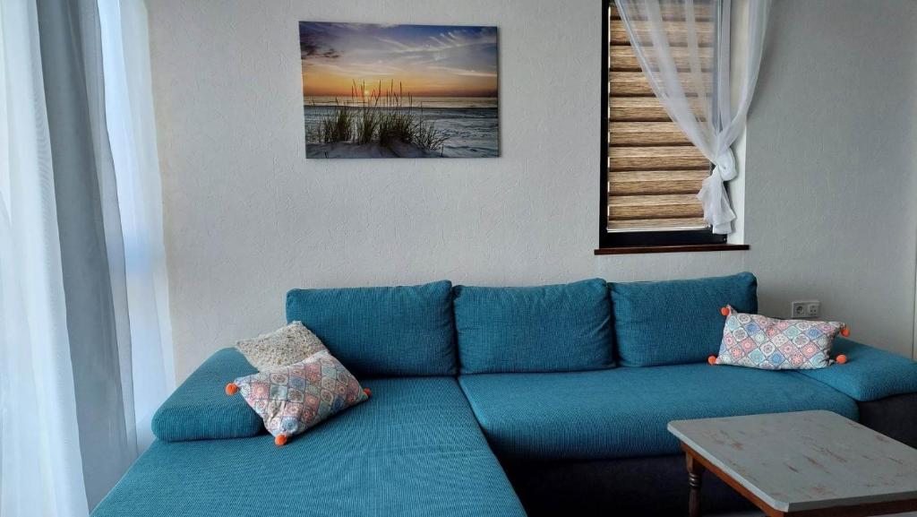 ein blaues Sofa im Wohnzimmer mit einem Tisch in der Unterkunft Anthic 7 Apartment 3 in Sozopol