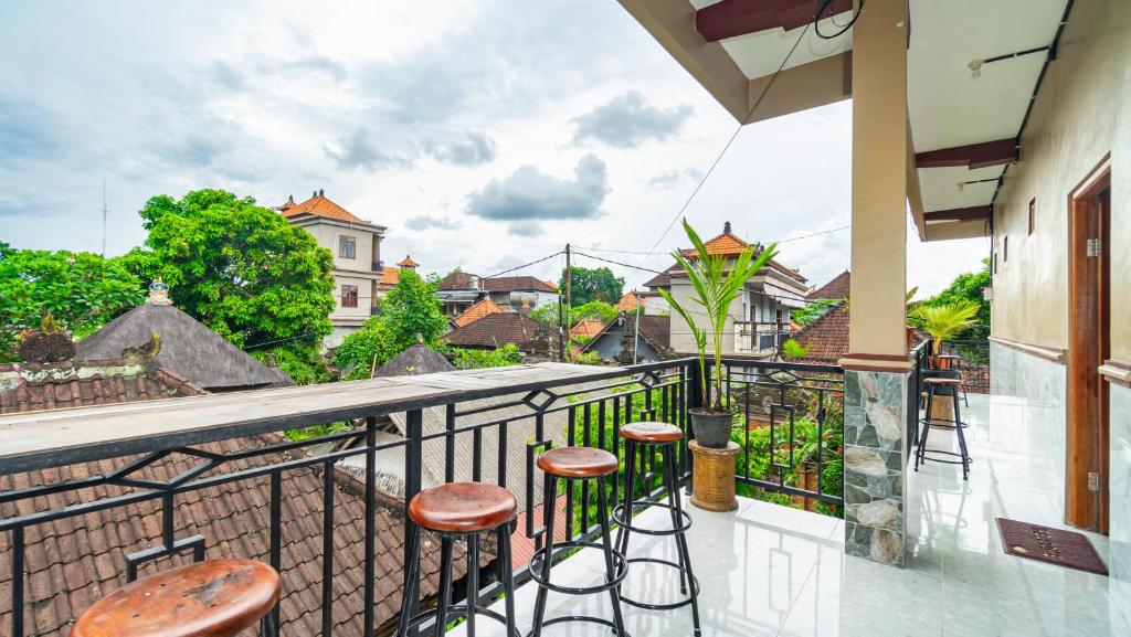 a balcony with stools and a view of a city at Peanut House in Ubud