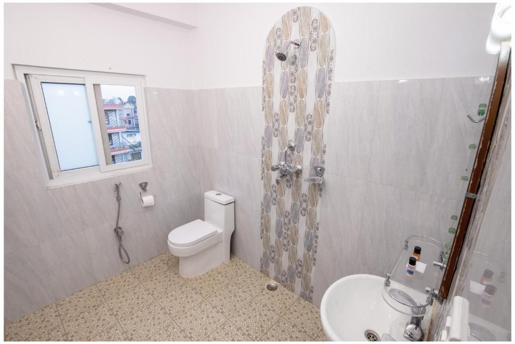 e bagno con servizi igienici, doccia e lavandino. di Hotel Tulip Pokhara Inn a Pokhara