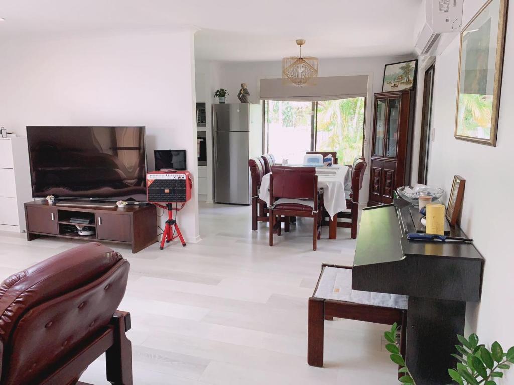 - un salon avec un canapé, une table et une télévision dans l'établissement Home Away From Home-(Room1), à Gold Coast