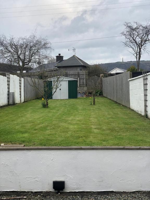 une arrière-cour avec une clôture et une cour d'herbe dans l'établissement Aga Cottage, à Headwood