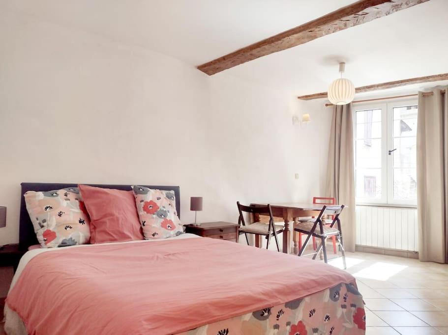 Studio Campanule Provence Verdon في ريز: غرفة نوم بسرير وطاولة مع كراسي