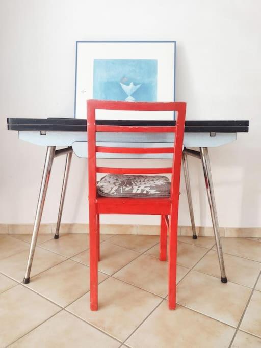 czerwone krzesło stojące przed biurkiem w obiekcie Studio Campanule Provence Verdon w mieście Riez