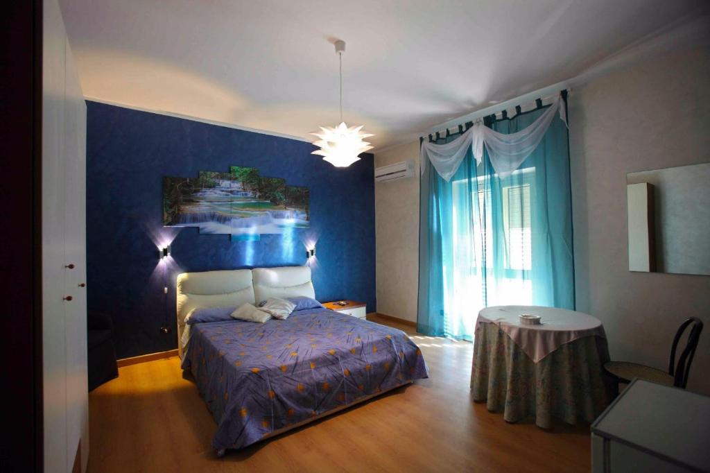 um quarto com uma cama e uma parede azul em B&B Villa Magna Grecia em Lazzaro