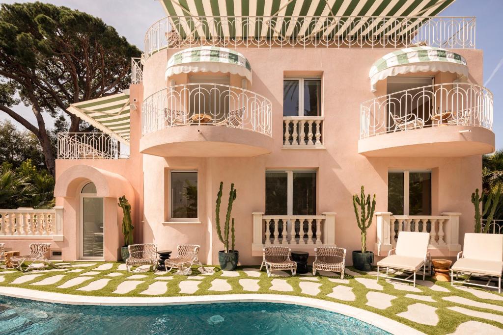 a villa with a swimming pool in front of a house at Maison Carla Rosa Cannes in Cannes