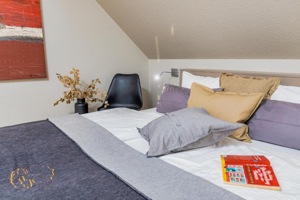 a bed with pillows and a book on it at Pier17 Appartement 3 in Borkum
